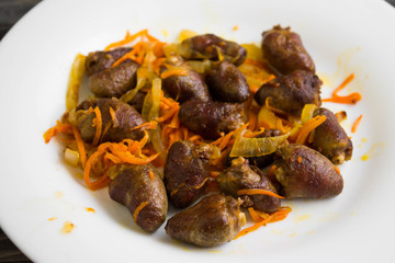 Fried chicken hearts with vegetables on a white plate