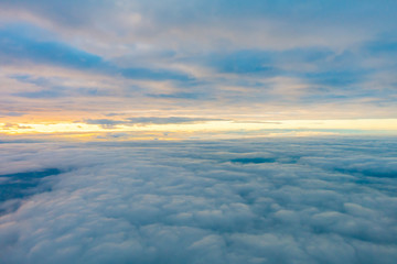 Fototapeta na wymiar Sunrise above clouds from airplane window .