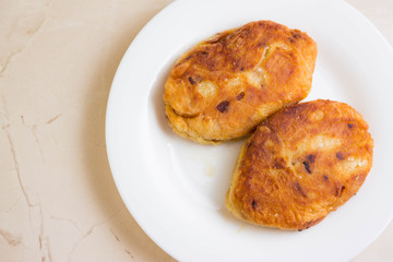 Potato patties with fried onions on a white plate