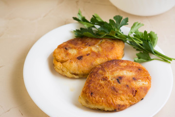 Potato patties with fried onions on a white plate
