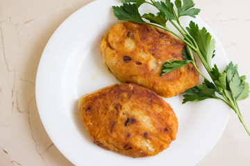 Potato patties with fried onions on a white plate