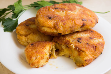 Potato patties with fried onions on a white plate