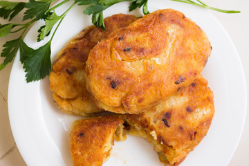 Potato patties with fried onions on a white plate