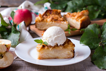 Closeup of a slice of apple pie with a scoop of ice cream on a plate