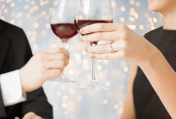close up of engaged couple with wine glasses