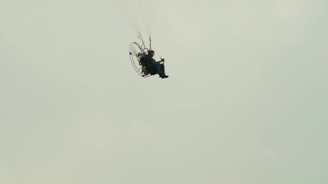 Man paragliding in cloudy sky