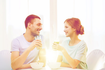 smiling couple having breakfast at home