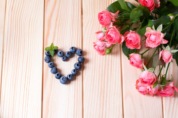 Beautiful roses and berries on a wooden background