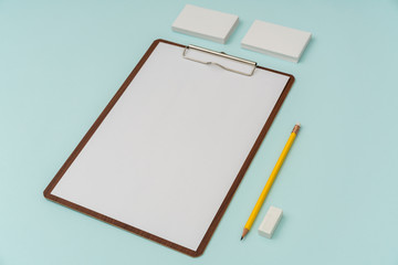 Clip board, paper,pencil  and business card on blue background .