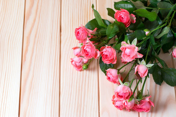 Bouquet of small pink roses on a wooden background
