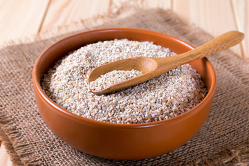 bowl of wheat grains on brown wooden background