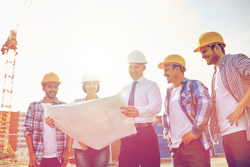 group of builders and architects with blueprint