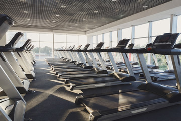 Modern gym interior with equipment, treadmills for fitness cardio training