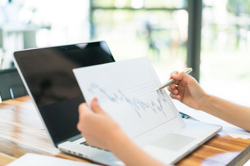 Business people using laptop and Financial charts at meeting off