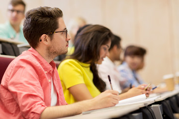 Fototapeta premium group of students with notebooks in lecture hall