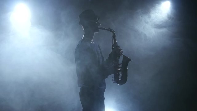 Slow play jazz music on saxophone on dark smoky studio