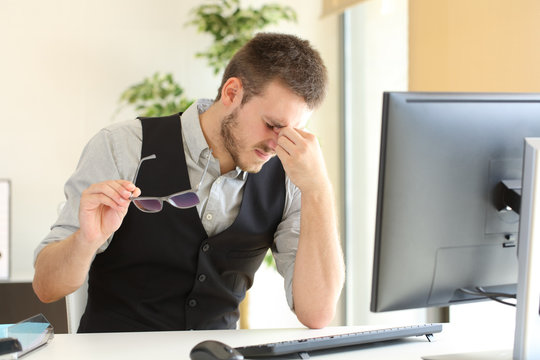 Businessman suffering eyestrain at office
