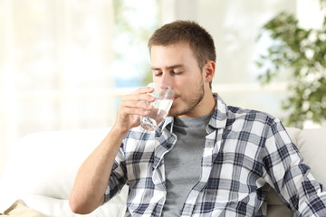 Fototapeta na wymiar Man drinking water at home