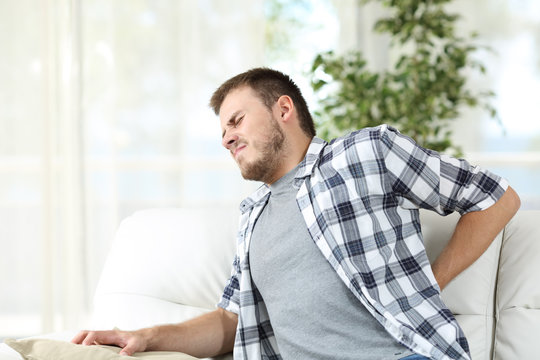 Man suffering back pain at home