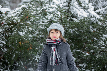 Happy little child, boy, playing outdoors in a snowy park