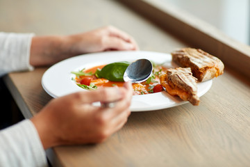 woman eating gazpacho soup at restaurant
