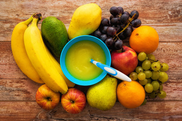 Baby fruit food. Raw fruits next to puree mash. Top view.