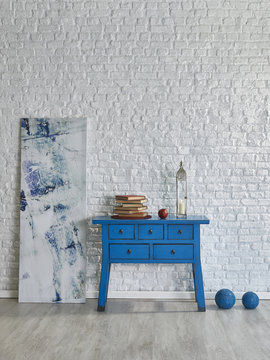 blue desk and handmade picture in front of the white brick wall