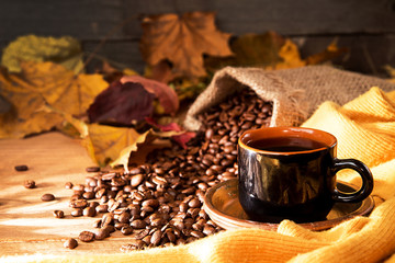 Cup of coffee, yellow scarf, roasted coffee beans