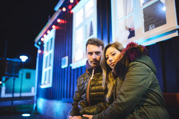 Man and Woman Sitting on Bench at Night