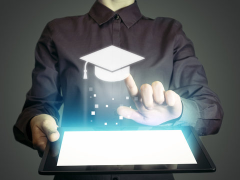 Image of a girl with a tablet in hands. She presses on the icon graduation hat cap. Online education concept, choose of career