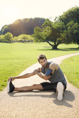 Fitness guy stretching in park