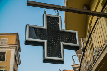 the cross - the sign of the pharmacy hanging on the streets of European cities