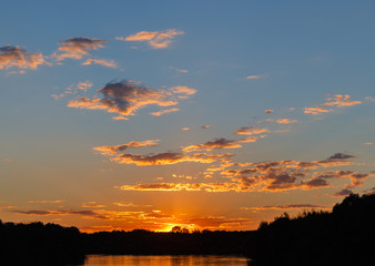 Sunset over the forest. Crimson clouds.