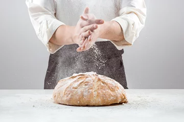 Wall murals Bread The male hands in flour and rustic organic loaf of bread