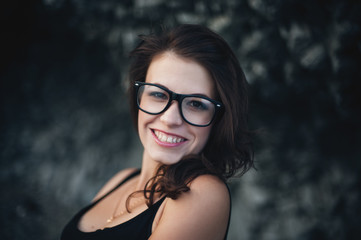 Sexy model in glasses and wearing the dress posing near the cliff