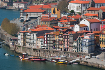 Fototapeta na wymiar Portogallo, 26/03/2012: barche e lo skyline di Porto con vista del fiume Douro tra le città di Porto e Vila Nova de Gaia