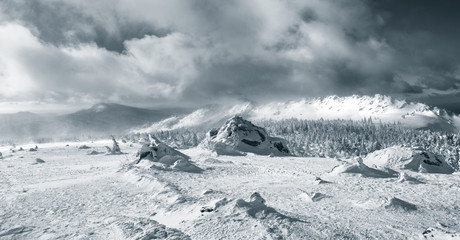 Panorama of mountains during snow storm tinted photo.