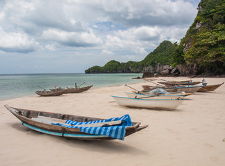 Fototapeta na wymiar Fishing boats parked on the beach during the day. (6)