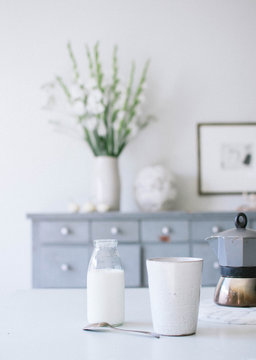 Milch in einer Glasflasche auf dem Esstisch in einem skandinavischen Zuhause