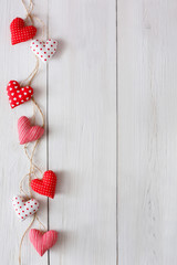 Valentine day background, pillow hearts border on wood, copy space