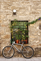 Fototapeta na wymiar Bicicleta apoyada sobre el muro de una casa, con ventana 