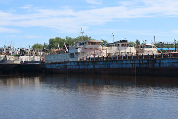 Fototapeta na wymiar Big rusty cargo ships are in bay on river at summer sunny day