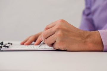 Close up Human Hand Signing on Formal Paper at the Table. 