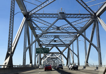Crossing the old section of the Oakland-San Francisco Bay Bridge under blue sky. Horizontal.