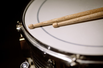 A snare drum and a pair of drum sticks.