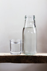 Drinking water in glass and bottle on a wooden floor.