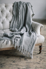 Still life details, wool grey plaid on retro vintage wooden sofa