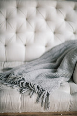 Still life details, wool grey plaid on retro vintage wooden sofa