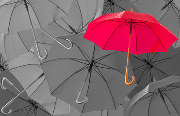 parasol rouge sur fond de parapluies en noir et blanc  © Unclesam
