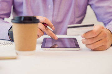 Concept for Internet shopping: hands with digital tablet and credit card